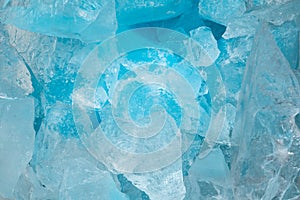 Pieces of crushed blue ice glass cracks background texture. close-up frozen water