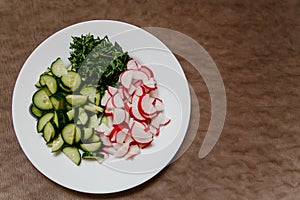 Pieces of cucumber and fresh radish on a white plate