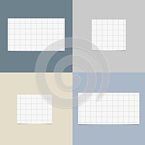 Pieces of cut white squared notebook paper with shadow are stuck on colorful background