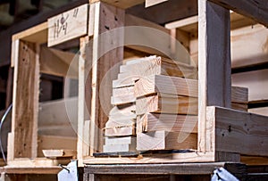 Pieces of cut wood are in crates in a work shop