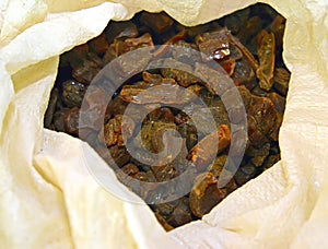 Pieces of dark untreated amber lie in white bag