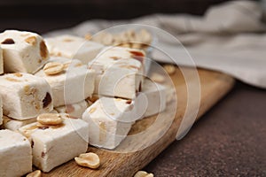 Pieces of delicious nutty nougat on brown table