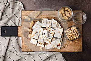 Pieces of delicious nutty nougat on brown table