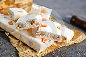 Pieces of delicious nutty nougat on table