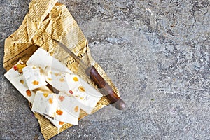 Pieces of delicious nutty nougat on table