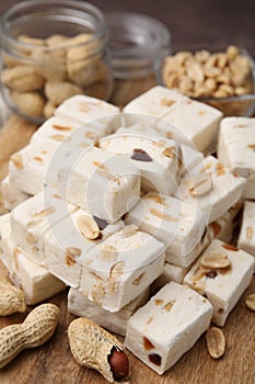 Pieces of delicious nutty nougat on table, closeup