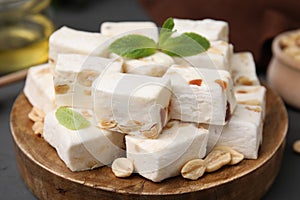 Pieces of delicious nutty nougat on wooden board