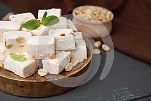 Pieces of delicious nutty nougat on wooden board, closeup