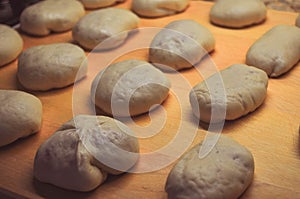 Pieces of dough stuffed with meat and jam close-up on a wooden board background.