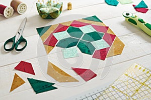 Pieces of fabric laid out in the shape of a patchwork block, sewing and quilting accessories