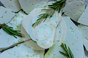 Pieces of feta cheese drenched with olive oil. Fragrant sprigs of fresh rosemary.