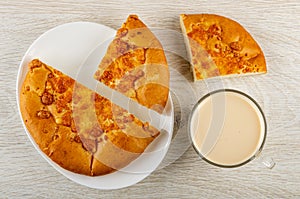 Pieces of flatbread with cheese in plate, cup with fermented baked milk on wooden table. Top view