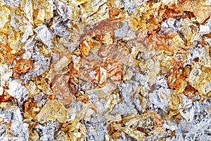 Pieces of foil or potal for a creative texture as festive background. Abstract bright pattern photo