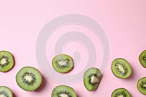Pieces of fresh kiwis on pink , flat lay. Space for text