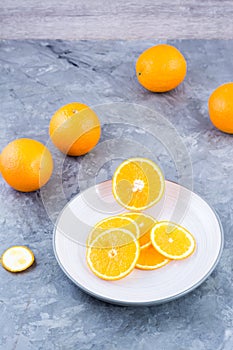 Pieces of fresh orange on a plate on the table. Vitamins, diet and vigor. Vertical view
