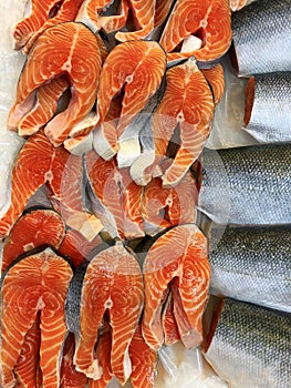 Pieces of fresh red fish cut for steak lying in a showcase in ice