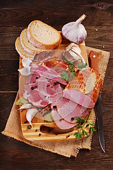 Pieces of fresh smoked ham on rural background