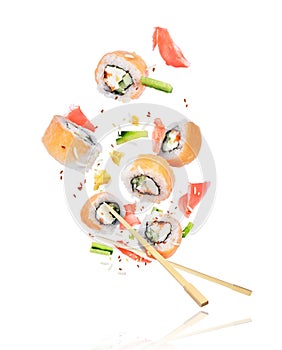 Pieces of fresh sushi with chopsticks frozen in the air on white