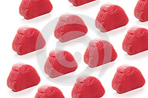 Pieces of fresh tuna on white background. A pattern of fish pieces. Isolated object.