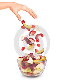 Pieces of fruit falling in a glass bowl