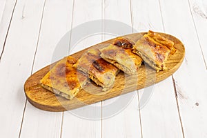 Pieces of Galician empanada cut into squares stuffed with tuna stew sprinkled