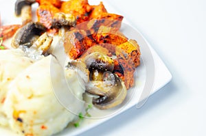 Pieces of grilled chicken breast in a sweet chilli marinade served with mashed potatoes, mushrooms, and fresh cherry tomatoes