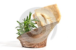 Pieces of handmade olive and herbs soap with rosemary on wood isolated on white