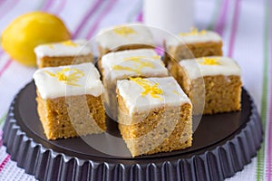 Pieces of homemade carrot cake with orange, lemon zest and icing cream. Selective focus.