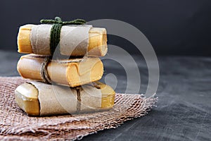 Pieces of household soap tied with jute rope, antique wooden background. Eco-friendly product - the concept of cleanliness and hea