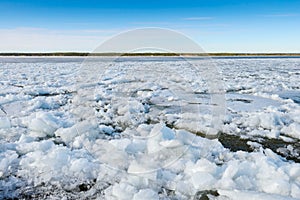 Pieces of ice float on river during the ice drift