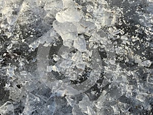 Fragments of beautiful broken ice lay on the ground and sparkle in the sun