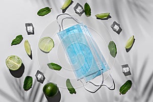 Pieces of lime, green mint and ice cubes on a white background. leisure, travel and entertainment concept with medical masks and