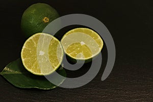 Pieces of lime and whole lime on a black background
