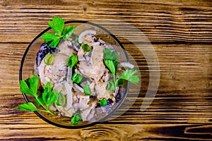 Pieces of the marinated carp fish in glass bowl on wooden table