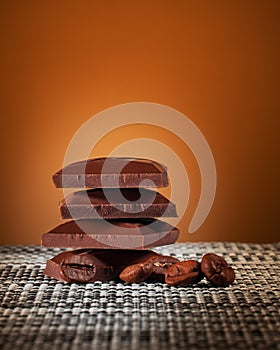 Pieces of milk chocolate on an orange gradient background