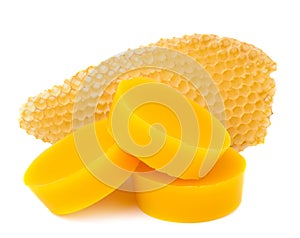 Pieces of natural beeswax and a piece of honey cell are isolated on a white background. Beekeeping products. Apitherapy.