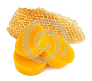 Pieces of natural beeswax and a piece of honey cell are isolated on a white background. Beekeeping products. Apitherapy.