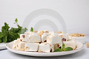 Pieces of nutty nougat on plate, closeup