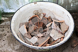 Pieces oof a brown clay pot in a bowl