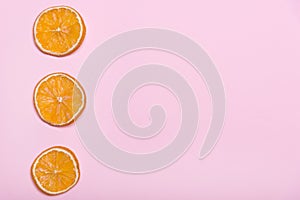 Pieces of orange. Circles with orange. Pink background. Citrus fruits.