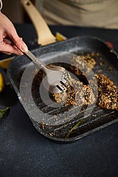 pieces of Organic Tuna fillet covered with sesame seeds frying on a hot grill pan