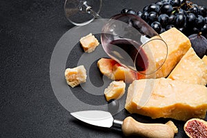 Pieces of parmesan or parmigiano cheese, wine and grapes