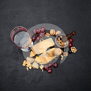 Pieces of parmesan or parmigiano cheese, wine and grapes