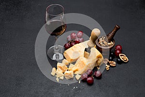 Pieces of parmesan or parmigiano cheese, wine and grapes