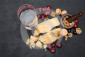 Pieces of parmesan or parmigiano cheese, wine and grapes