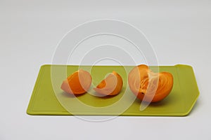 Pieces of persimmon on a cutting board, proper nutrition