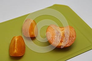 Pieces of persimmon on a cutting board, proper nutrition