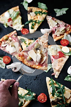 Pieces of pizza of different various types on black background still life concepton