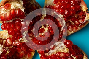 Pieces of pomegranate on a blue background. Vitamins and minerals. Concept healthy food. Top view. Flat lay. Close up