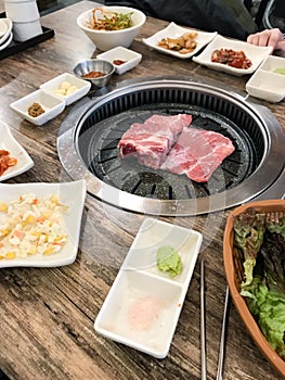 Pieces of pork are frying in korean BBQ grill